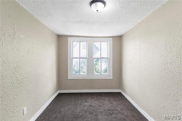503 Newberry St, Fredericktown, MO 63645 - spare room featuring a textured wall, baseboards, a textured ceiling, and dark colored carpet
