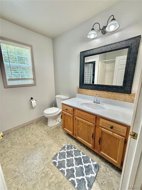 720 S Main St, Arcadia, MO 63621 - bathroom with vanity, toilet, and baseboards