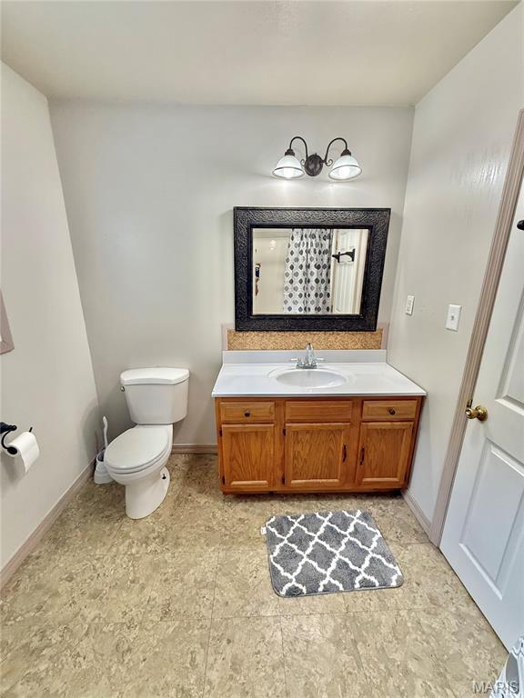 720 S Main St, Arcadia, MO 63621 - full bath with vanity, toilet, and baseboards