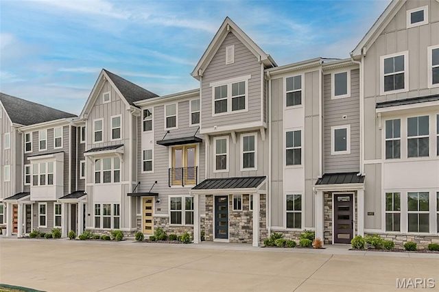 8923 Gateway Hts Unit 94-805, Richmond Heights, MO 63144 - townhome / multi-family property featuring board and batten siding, a standing seam roof, stone siding, and metal roof