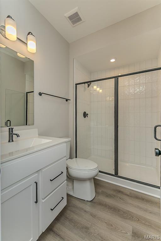 8923 Gateway Hts Unit 94-805, Richmond Heights, MO 63144 - full bath with vanity, toilet, wood finished floors, and a shower stall