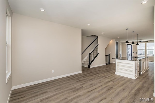 8923 Gateway Hts Unit 94-805, Richmond Heights, MO 63144 - kitchen featuring a sink, baseboards, dark countertops, an island with sink, and recessed lighting