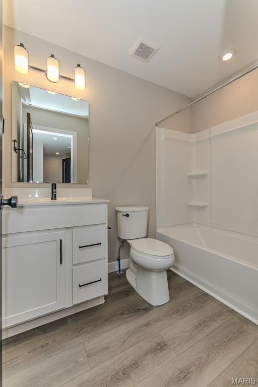 8923 Gateway Hts Unit 94-805, Richmond Heights, MO 63144 - bathroom with toilet, wood finished floors, vanity, bathing tub / shower combination, and recessed lighting