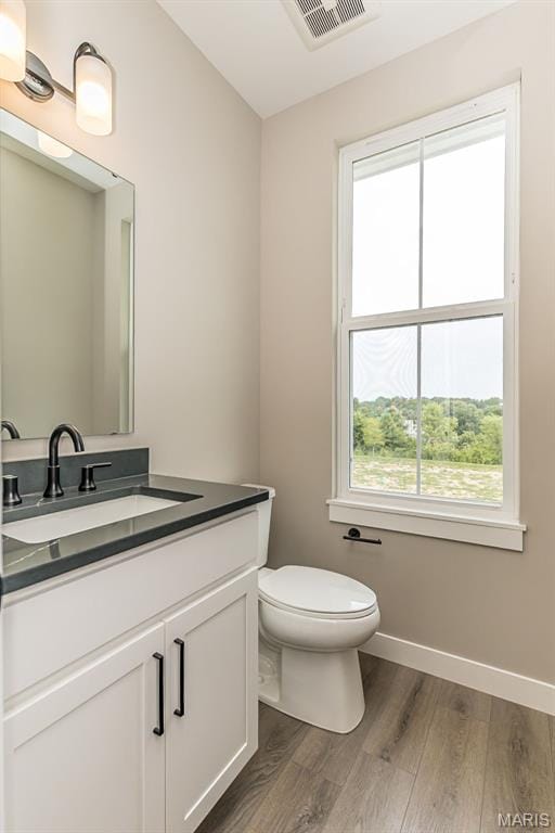 8923 Gateway Hts Unit 94-805, Richmond Heights, MO 63144 - bathroom with wood finished floors, vanity, toilet, and baseboards