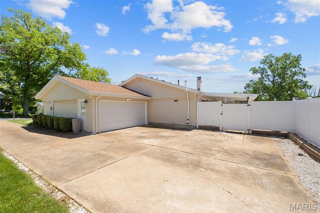 116 Lea Meadows Dr, Ballwin, MO 63011 - view of side of home with a gate, an attached garage, concrete driveway, and a shingled roof
