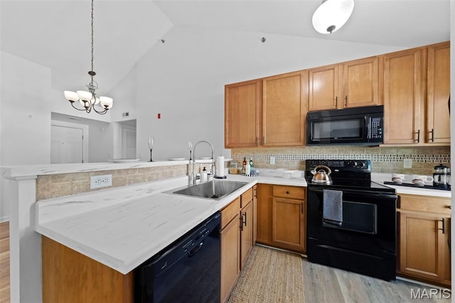 9740 Bexley Station Dr Unit 7J, Concord Township, MO 63123 - kitchen featuring black appliances, a sink, a peninsula, light wood finished floors, and tasteful backsplash