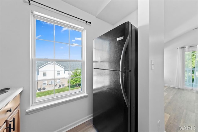 9740 Bexley Station Dr Unit 7J, Concord Township, MO 63123 - kitchen view of freestanding refrigerator, light wood-style flooring, baseboards, and light countertops
