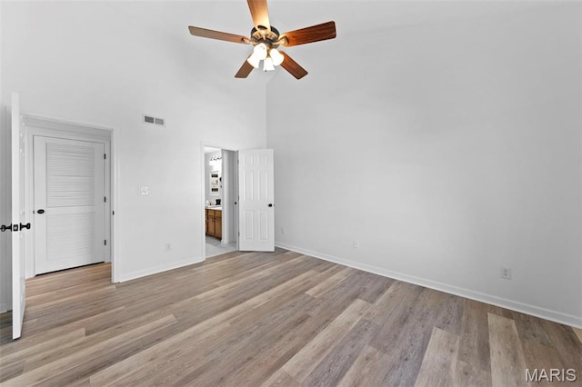 9740 Bexley Station Dr Unit 7J, Concord Township, MO 63123 - unfurnished bedroom featuring a high ceiling, baseboards, wood finished floors, connected bathroom, and a ceiling fan