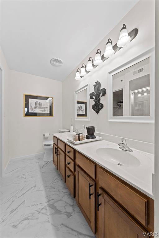 9740 Bexley Station Dr Unit 7J, Concord Township, MO 63123 - full bathroom featuring marble look tiles, double vanity, toilet, and a shower