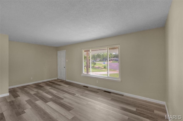 220 Versailles Dr, Florissant, MO 63031 - spare room featuring wood finished floors and a textured ceiling