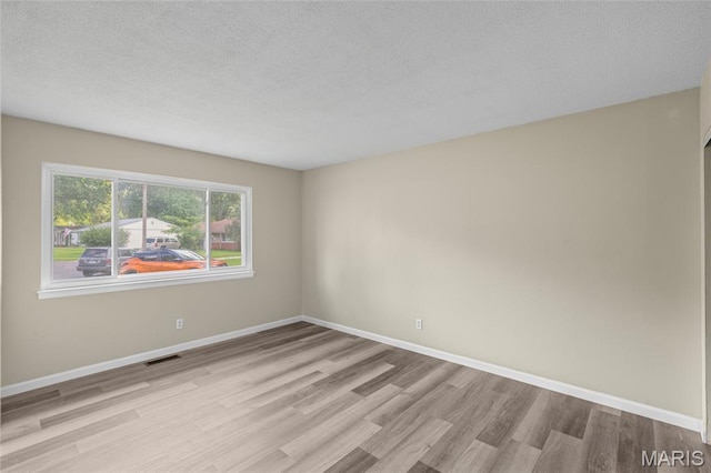 220 Versailles Dr, Florissant, MO 63031 - empty room featuring light wood-type flooring and a textured ceiling