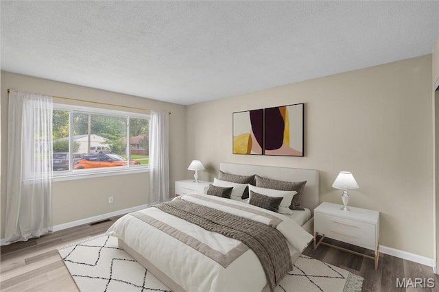 220 Versailles Dr, Florissant, MO 63031 - bedroom with wood finished floors and a textured ceiling