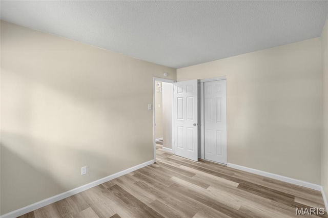 220 Versailles Dr, Florissant, MO 63031 - empty room featuring light wood-style flooring and a textured ceiling