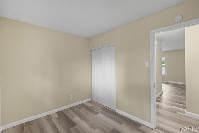 220 Versailles Dr, Florissant, MO 63031 - unfurnished bedroom with wood finished floors and a closet