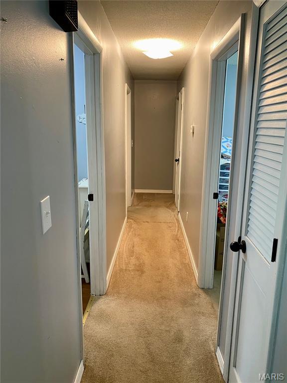 702 E Silver, Naylor, MO 63953 - corridor featuring light colored carpet, a textured ceiling, and baseboards