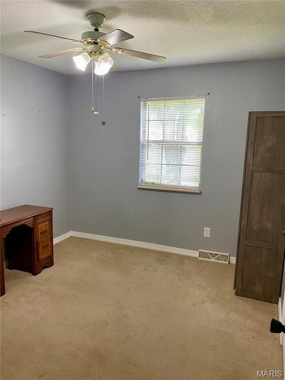 702 E Silver, Naylor, MO 63953 - empty room featuring light colored carpet, ceiling fan, a textured ceiling, and baseboards