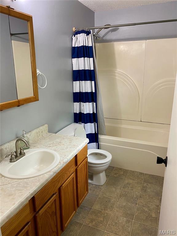 702 E Silver, Naylor, MO 63953 - bathroom featuring vanity, toilet, shower / bath combination with curtain, and a textured ceiling
