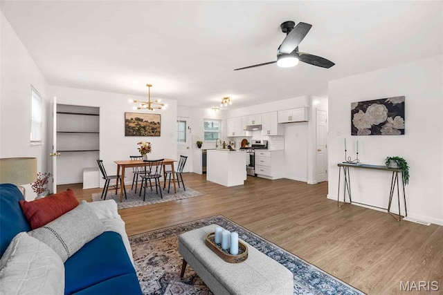 216 Clearpoint Ln, Saint Louis, MO 63123 - living room featuring a chandelier, wood finished floors, a ceiling fan, and baseboards