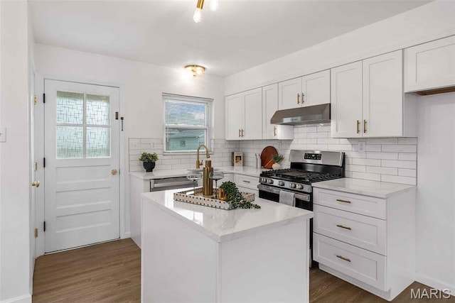 216 Clearpoint Ln, Saint Louis, MO 63123 - kitchen featuring under cabinet range hood, white cabinetry, dark wood finished floors, decorative backsplash, and a center island