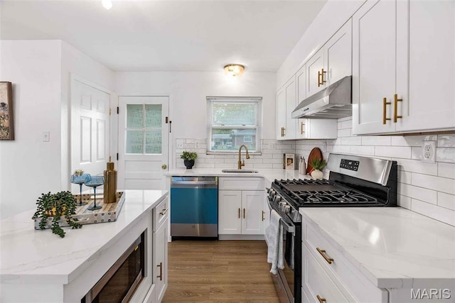 216 Clearpoint Ln, Saint Louis, MO 63123 - kitchen featuring appliances with stainless steel finishes, under cabinet range hood, a sink, white cabinetry, and backsplash