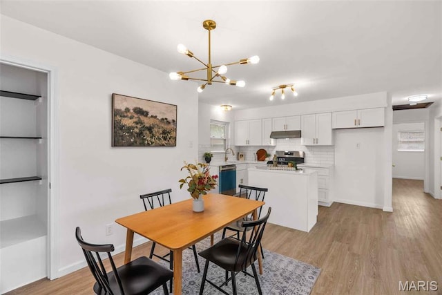 216 Clearpoint Ln, Saint Louis, MO 63123 - dining area featuring a chandelier, light wood-style flooring, and baseboards