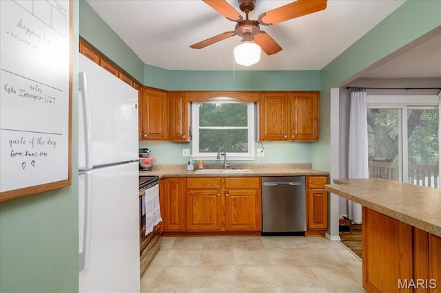 1170 Bond St, Carlyle, IL 62231 - kitchen featuring stainless steel appliances, a sink, brown cabinetry, ceiling fan, and light countertops