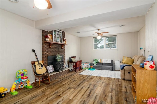 1170 Bond St, Carlyle, IL 62231 - living room featuring a wood stove, wood finished floors, and a ceiling fan