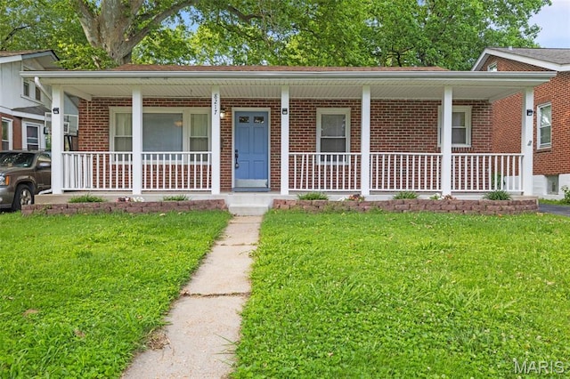 8217 Buchanan Ave, Saint Louis, MO 63114 - view of front of house featuring a porch, brick siding, and a front yard