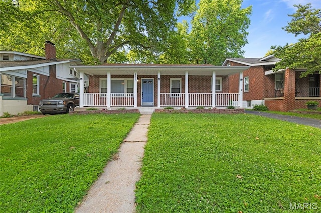 8217 Buchanan Ave, Saint Louis, MO 63114 - view of front of property with a porch, brick siding, a front yard, and a chimney