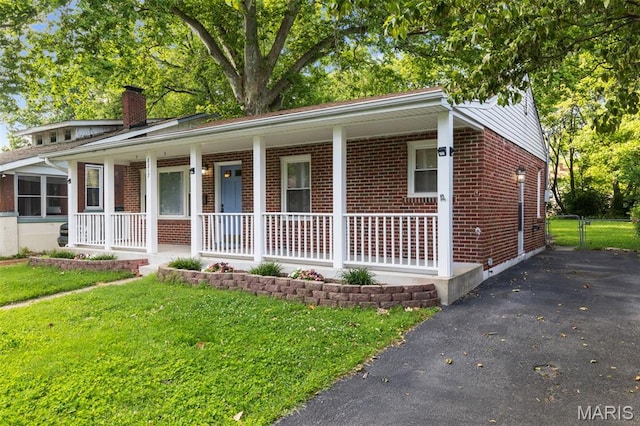 8217 Buchanan Ave, Saint Louis, MO 63114 - ranch-style home featuring a porch, brick siding, a chimney, and asphalt driveway