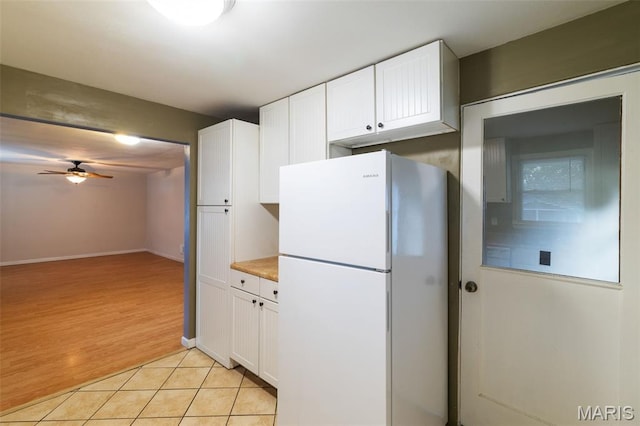 8217 Buchanan Ave, Saint Louis, MO 63114 - kitchen with freestanding refrigerator, white cabinetry, ceiling fan, light tile patterned floors, and light countertops