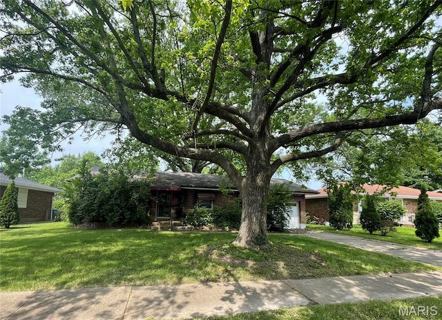329 Kirk Dr, Ferguson, MO 63135 - obstructed view of property with an attached garage, a front lawn, driveway, and brick siding