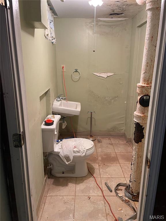 329 Kirk Dr, Ferguson, MO 63135 - bathroom featuring toilet, tile patterned floors, and a sink