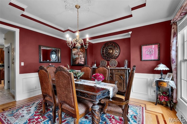 807 Caribou Ct, Cape Girardeau, MO 63701 - dining room featuring wainscoting, a chandelier, a raised ceiling, crown molding, and a decorative wall