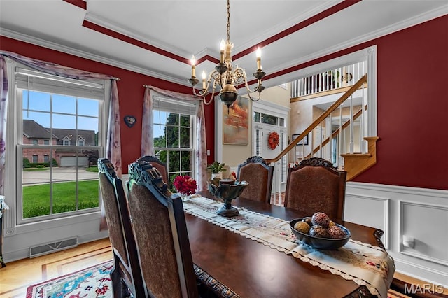 807 Caribou Ct, Cape Girardeau, MO 63701 - dining area featuring a chandelier, ornamental molding, stairs, wainscoting, and a decorative wall
