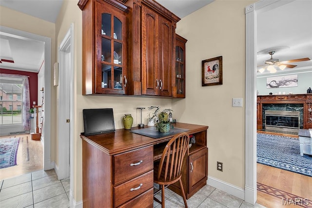 807 Caribou Ct, Cape Girardeau, MO 63701 - home office with ceiling fan, light tile patterned floors, baseboards, a high end fireplace, and built in study area