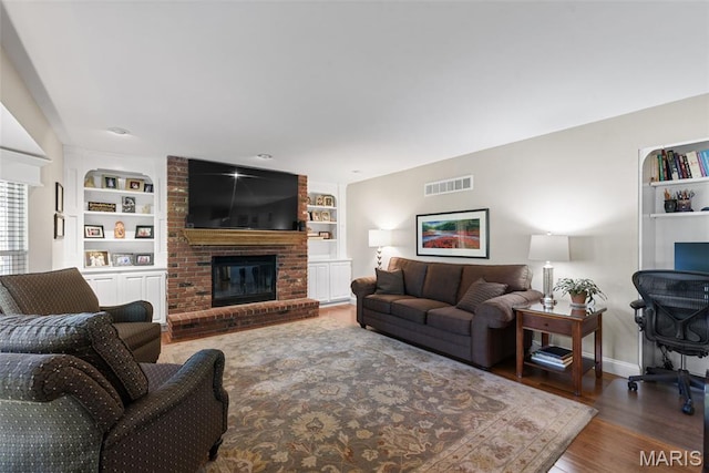 113 Christine Cay Ct, Saint Charles, MO 63304 - living area with built in features, wood finished floors, a fireplace, and baseboards