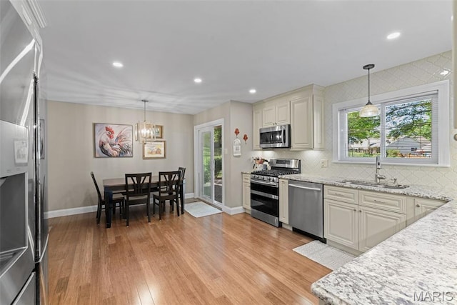 113 Christine Cay Ct, Saint Charles, MO 63304 - kitchen featuring appliances with stainless steel finishes, a sink, baseboards, light wood-style flooring, and recessed lighting