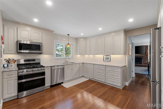113 Christine Cay Ct, Saint Charles, MO 63304 - kitchen with appliances with stainless steel finishes, hardwood / wood-style flooring, backsplash, light stone counters, and recessed lighting