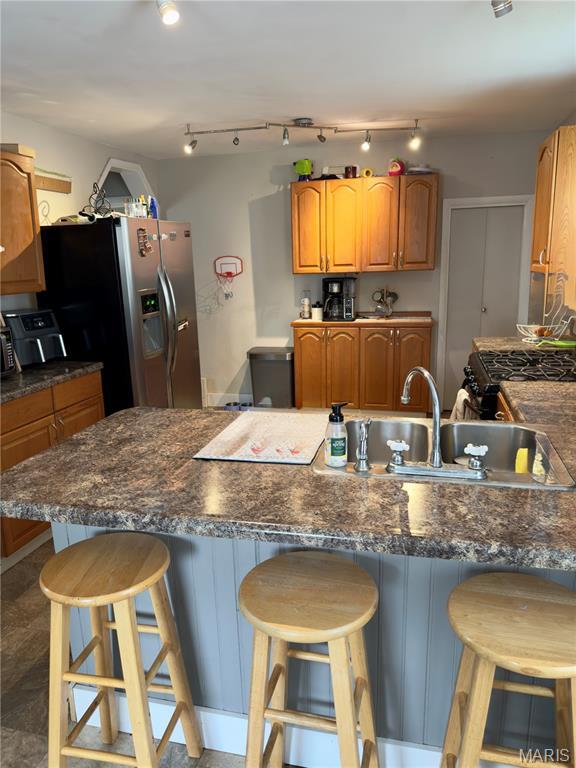 518 Randle St, Edwardsville, IL 62025 - kitchen featuring stainless steel refrigerator with ice dispenser, a kitchen bar, dark countertops, and a peninsula