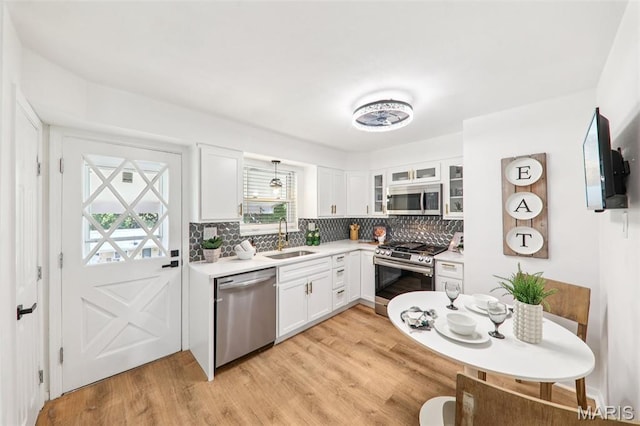 1525 79th St, Saint Louis, MO 63130 - kitchen with appliances with stainless steel finishes, plenty of natural light, white cabinetry, and backsplash