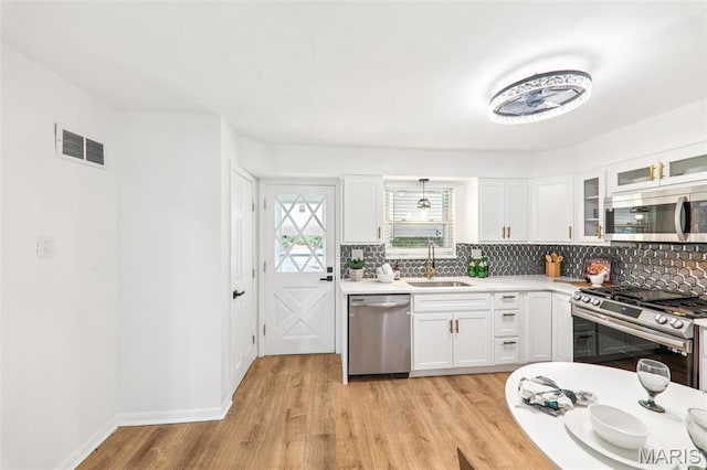 1525 79th St, Saint Louis, MO 63130 - kitchen featuring stainless steel appliances, tasteful backsplash, light countertops, and white cabinets