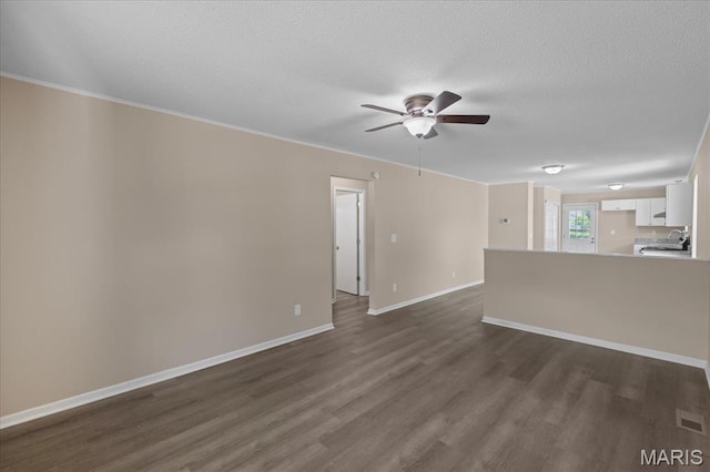 206 6th St, Park Hills, MO 63601 - unfurnished living room with dark wood-type flooring, ceiling fan, baseboards, a textured ceiling, and a sink