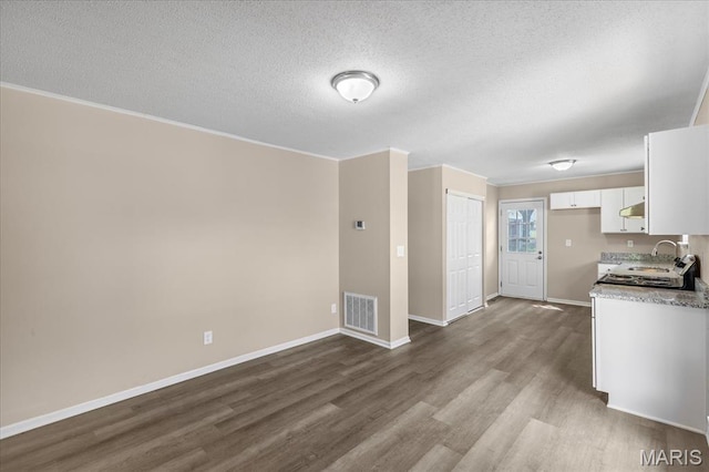 206 6th St, Park Hills, MO 63601 - kitchen featuring dark wood-style floors, a sink, white cabinetry, a textured ceiling, and baseboards