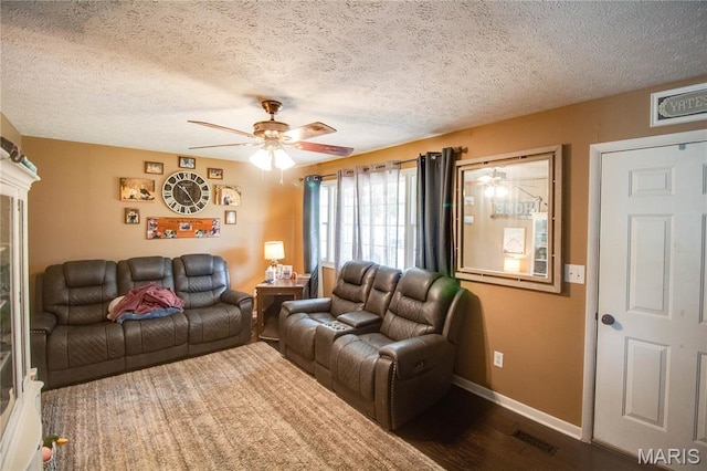 906 E Fairgrounds Ave, Jerseyville, IL 62052 - living area featuring a ceiling fan, dark wood-style floors, baseboards, and a textured ceiling