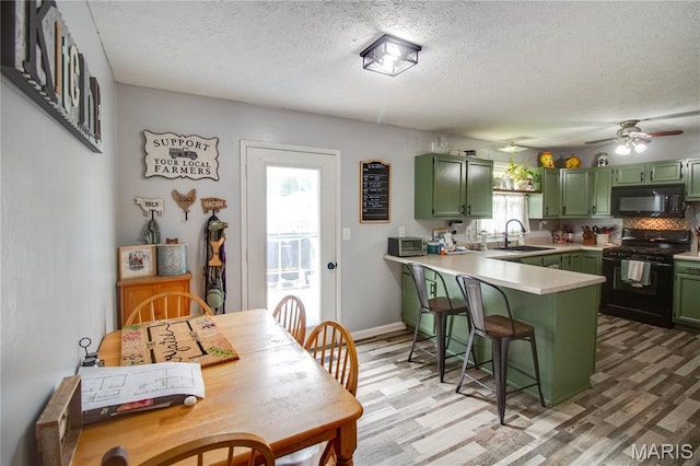 906 E Fairgrounds Ave, Jerseyville, IL 62052 - kitchen with green cabinetry, black appliances, a sink, a peninsula, and a textured ceiling