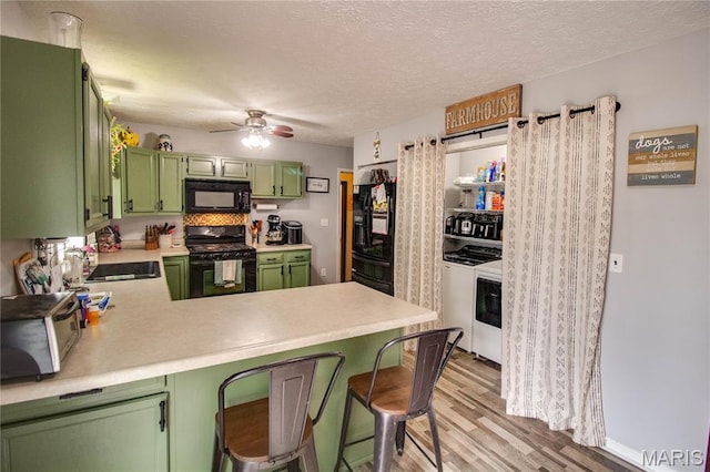 906 E Fairgrounds Ave, Jerseyville, IL 62052 - kitchen featuring green cabinetry, black appliances, light countertops, light wood-type flooring, and a ceiling fan