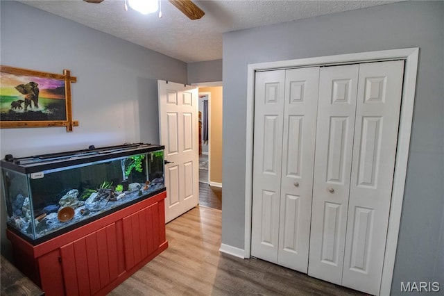 906 E Fairgrounds Ave, Jerseyville, IL 62052 - bedroom featuring wood finished floors, a closet, a textured ceiling, baseboards, and ceiling fan