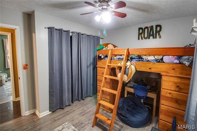 906 E Fairgrounds Ave, Jerseyville, IL 62052 - bedroom featuring a textured ceiling, wood finished floors, an office area, baseboards, and a ceiling fan