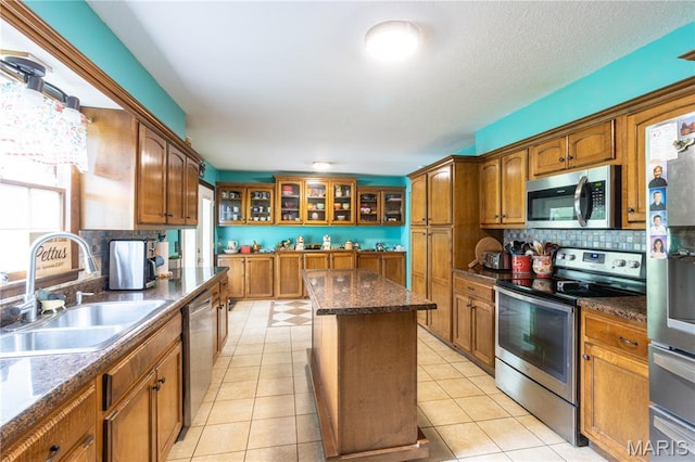 465 County Road 5120, Salem, MO 65560 - kitchen with appliances with stainless steel finishes, tasteful backsplash, brown cabinetry, a center island, and glass insert cabinets